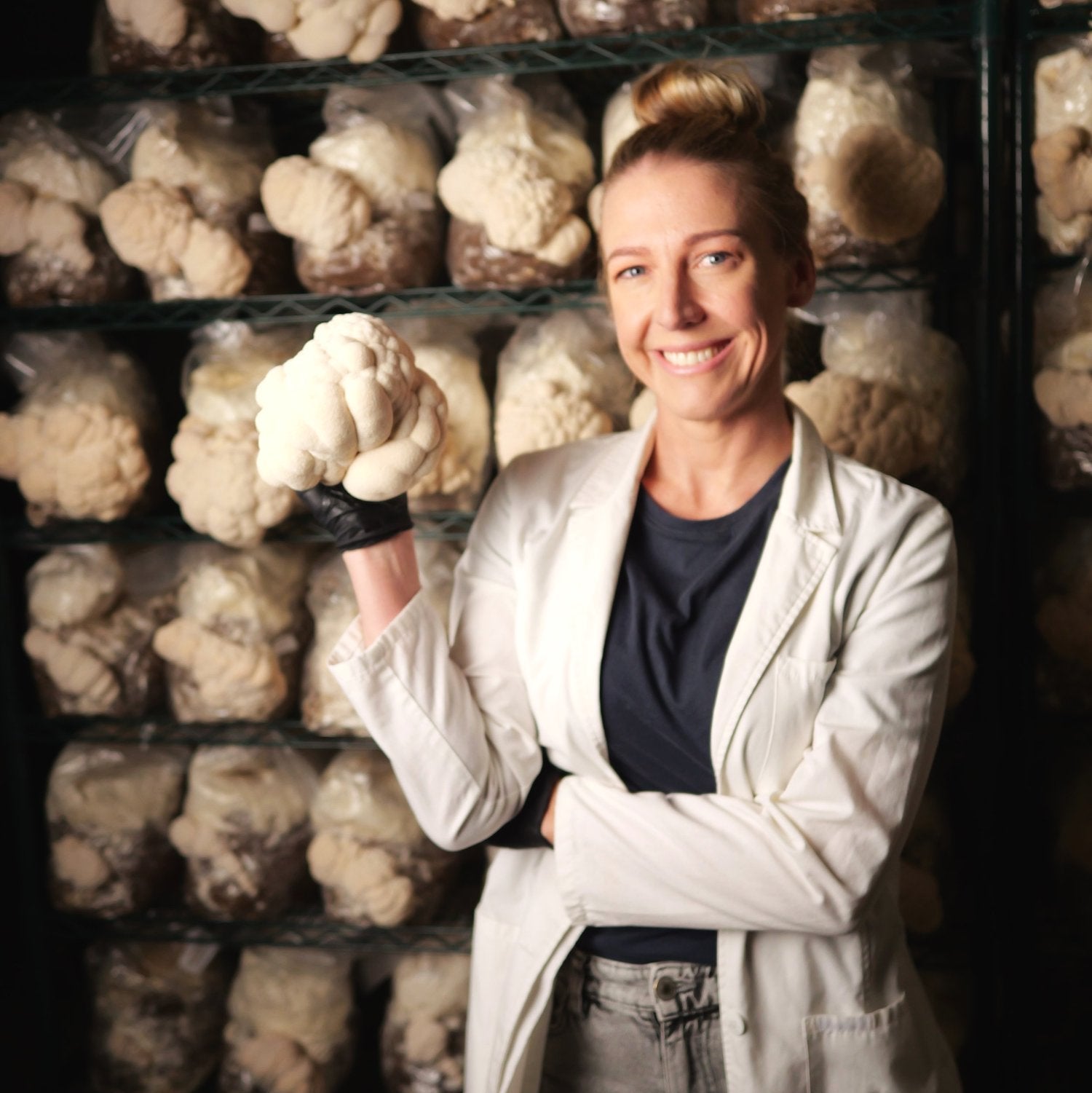 MYCOfactor founder Rachel in front of Lion's Mane growing at Urban Valley in their grow room
